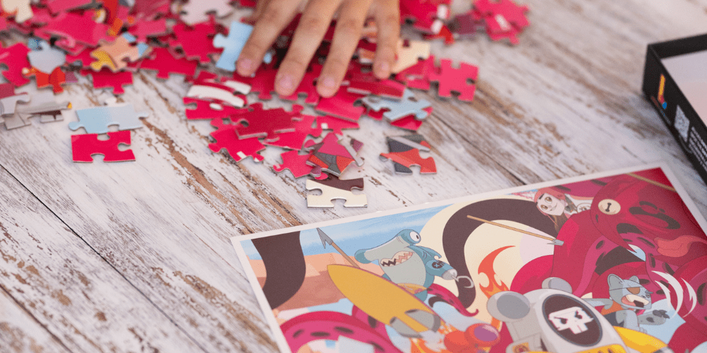 Child’s hands sorting jigsaw puzzle pieces, developing focus and fine motor skills with Lalita’s Art Shop puzzle