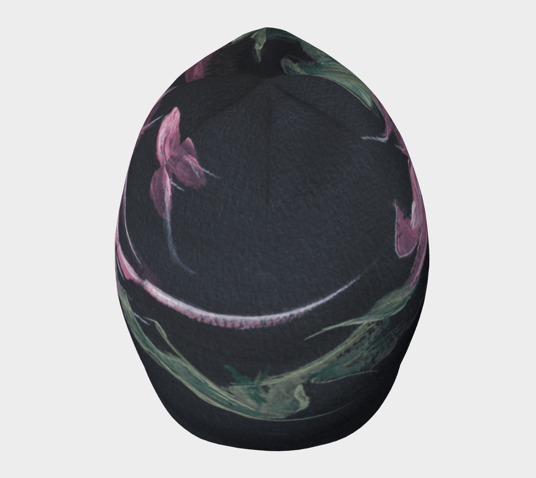 Une tuque noire avec un imprimé floral abstrait rose et vert vue de dessus avec un motif incurvé.