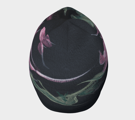 Une tuque noire avec un imprimé floral abstrait rose et vert vue de dessus avec un motif incurvé.