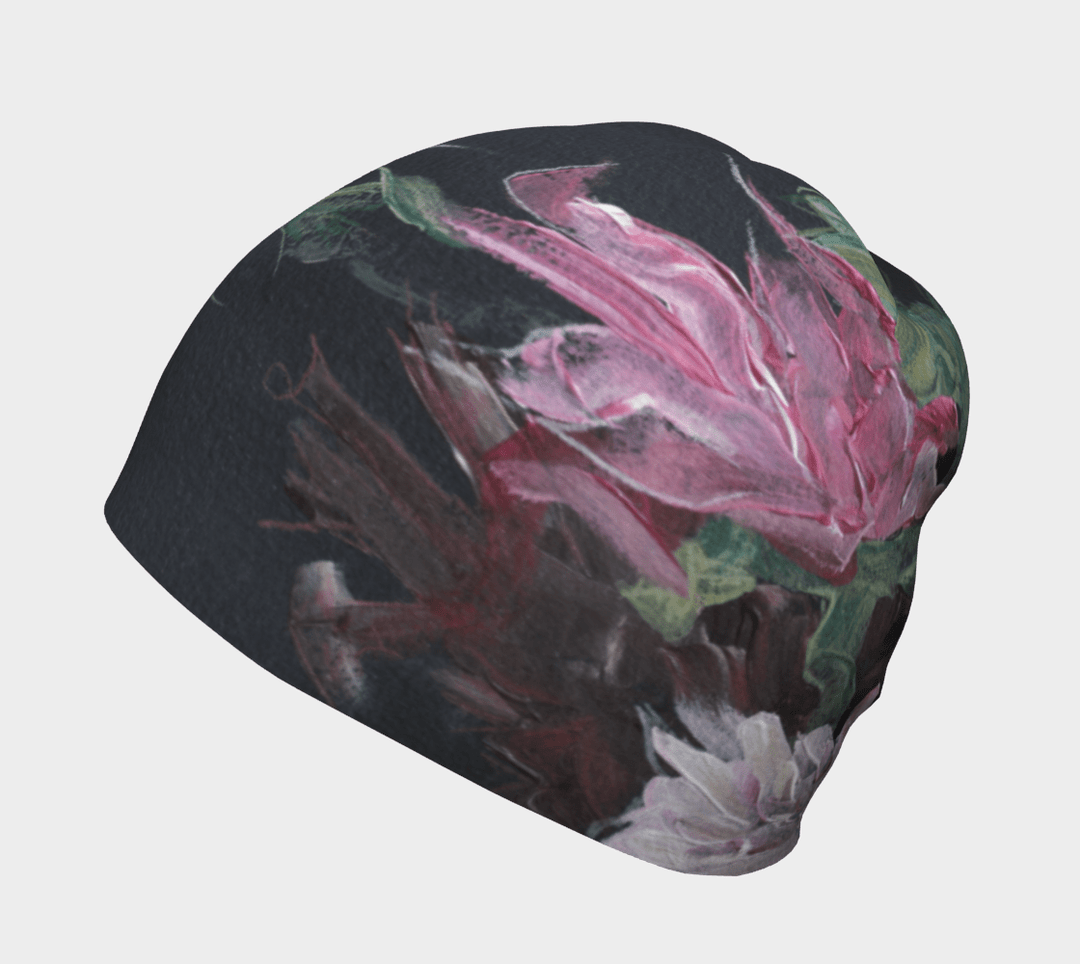 Une tuque noire avec un imprimé floral abstrait aux couleurs vives, rose et vert, vue de côté.