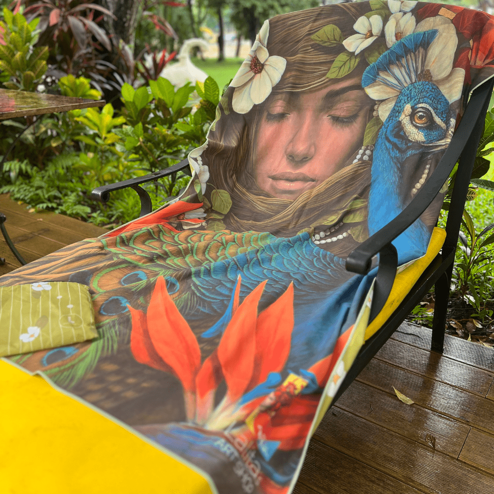 La serviette de plage artistique Chrysalide drapée sur une chaise d&