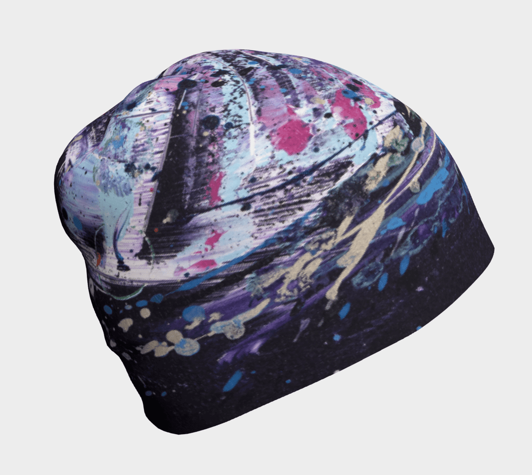 Close-up of a beanie with a vibrant, abstract splash-art design in purple, blue, and pink.