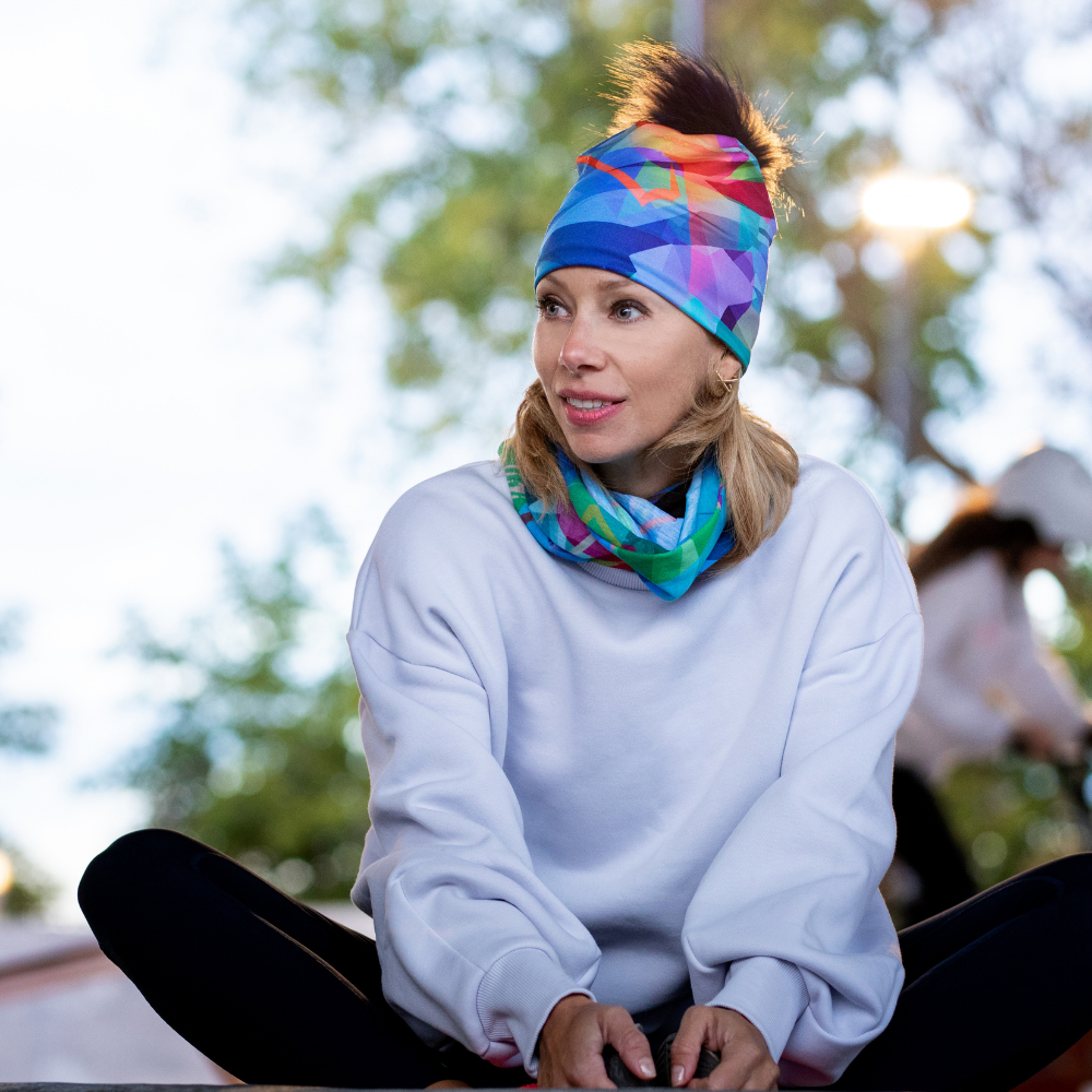 Woman wearing a white sweatshirt and the abstract pattern neck tube as a headband and around her neck.