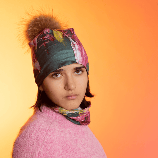 Une jeune personne portant la Tuque Fleur Glitch et une cache-cou assortie, regardant vers l&