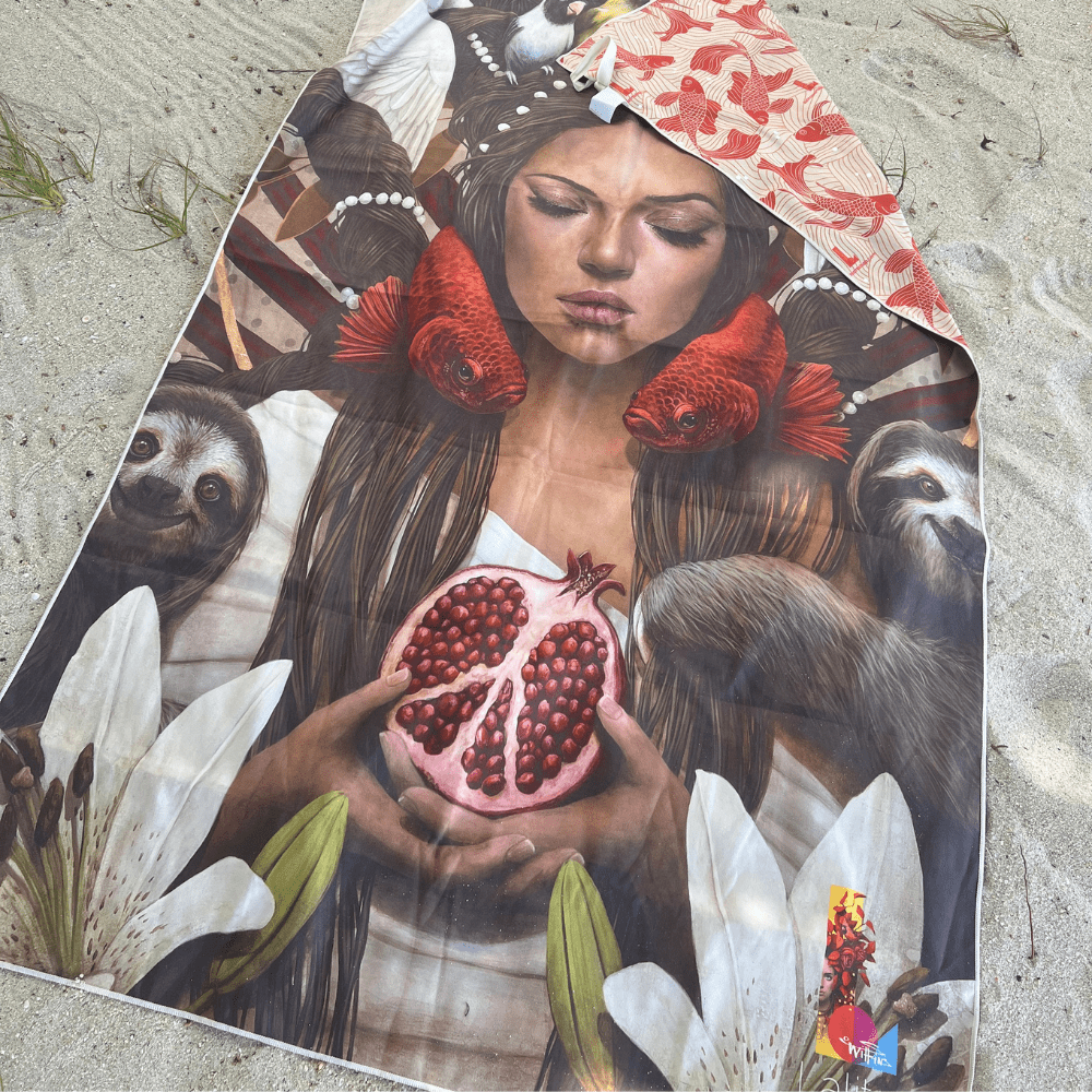 La serviette Guerrière Pacifique étendue sur le sable, montrant le côté artistique avec une femme et la nature.