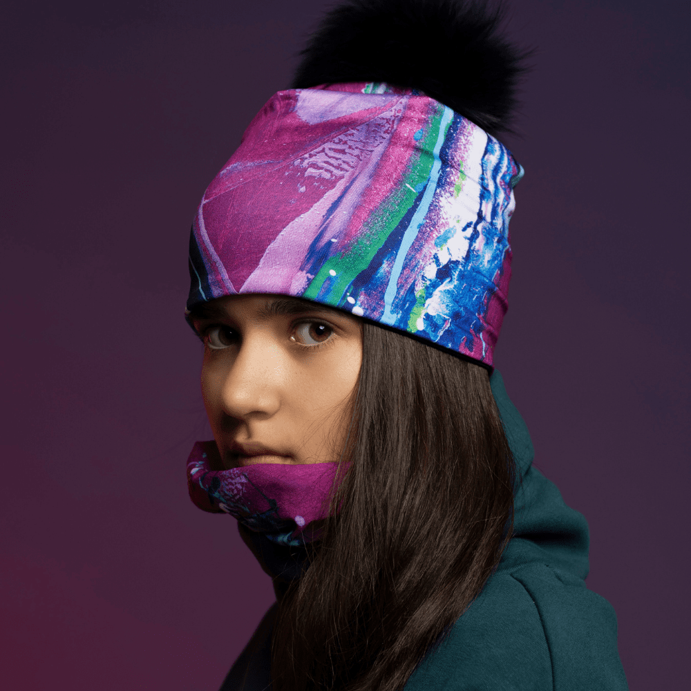 Une jeune personne portant le tube Espoir en tuque et autour du cou, sur fond violet.