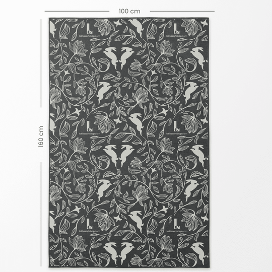 Gros plan du côté à motif de la grande serviette artistique réversible, montrant le design de lapin et de fleurs avec les dimensions de 100 cm par 160 cm.