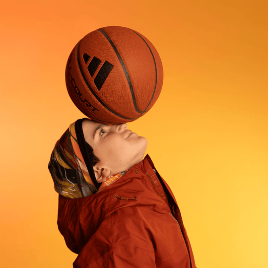 Personne portant la tuque Le Cœur avec un ballon de basket en équilibre sur sa tête.