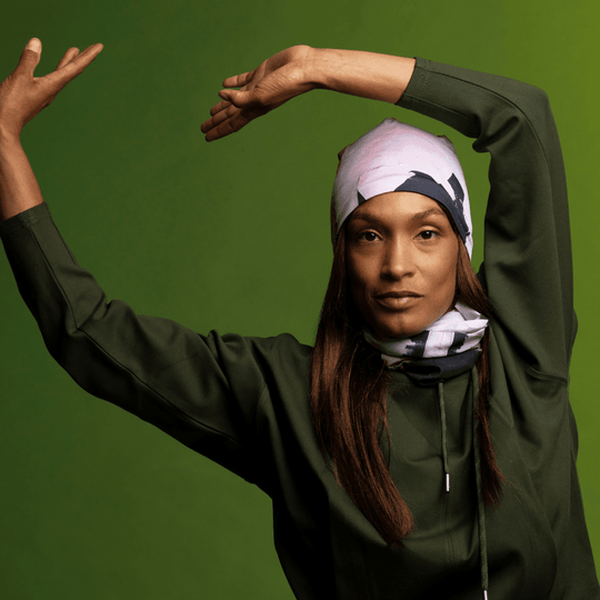 Mannequin portant un haut vert foncé, posant les bras levés, avec un imprimé matelassé moderne en bandana.