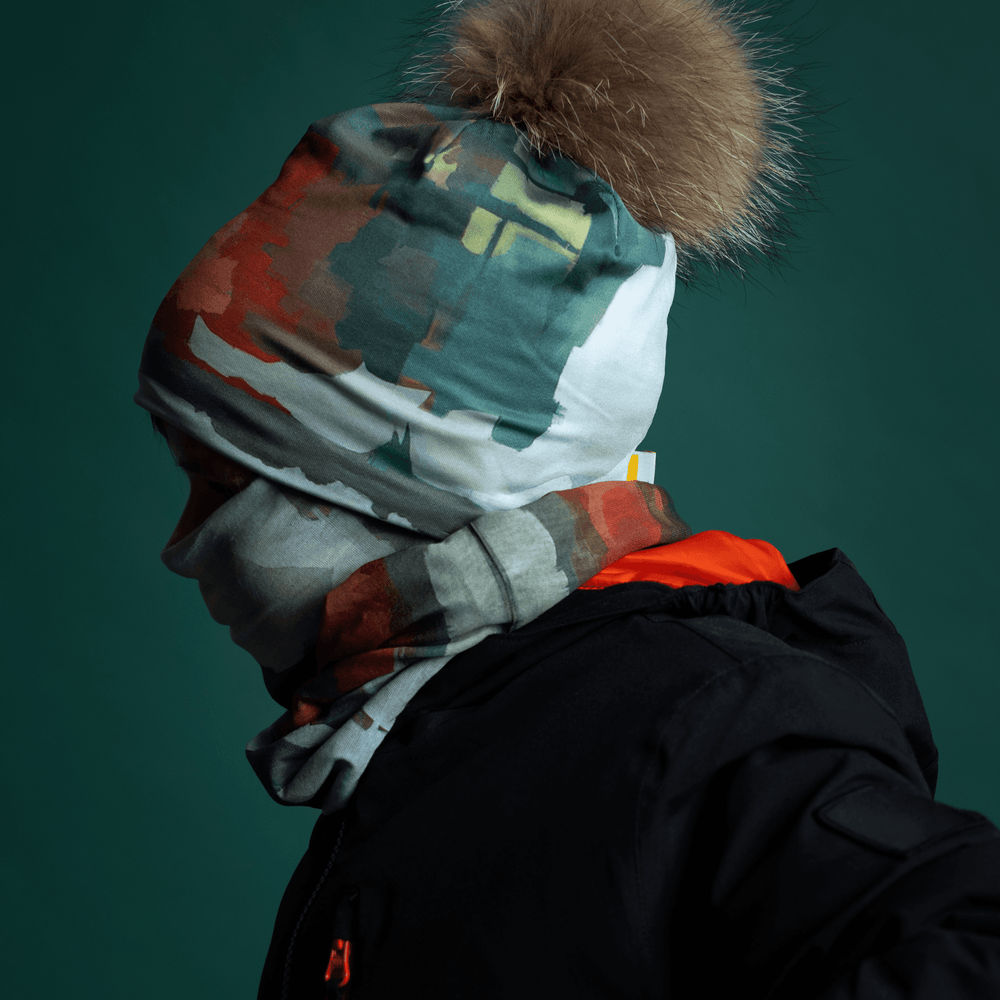 Mannequin portant une veste d'hiver noire avec une tuque et un cache-cou ornés d'une impression d'art abstrait coloré.