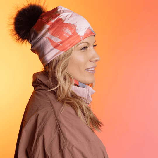 Femme portant la tuque Rose et Flammes avec un pompon noir, de profil.