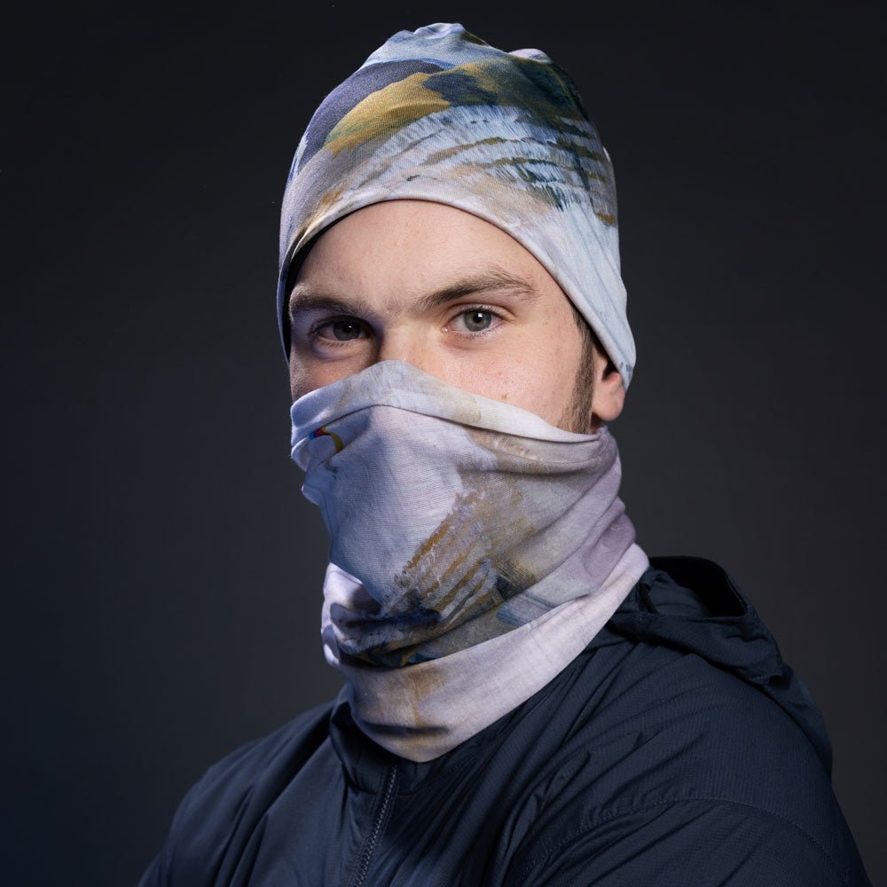 Homme portant une veste marine, avec le tissu à imprimé abstrait en masque facial et tuque.