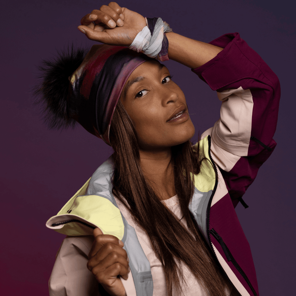 Femme portant la tuque artistique abstraite avec cache-cou assorti et veste de ski colorée.