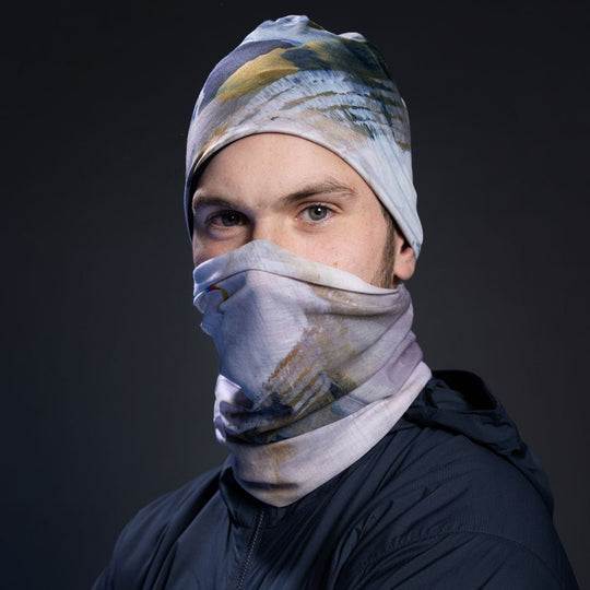 A man wearing the Unisex Sand Beanie and neck tube as a face covering.