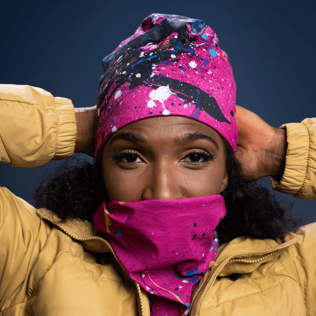 Femme portant le tube rose à motif abstrait remonté en protection faciale.