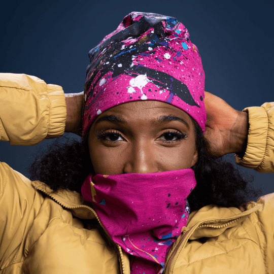 Femme portant le tube rose à motif abstrait remonté en protection faciale.