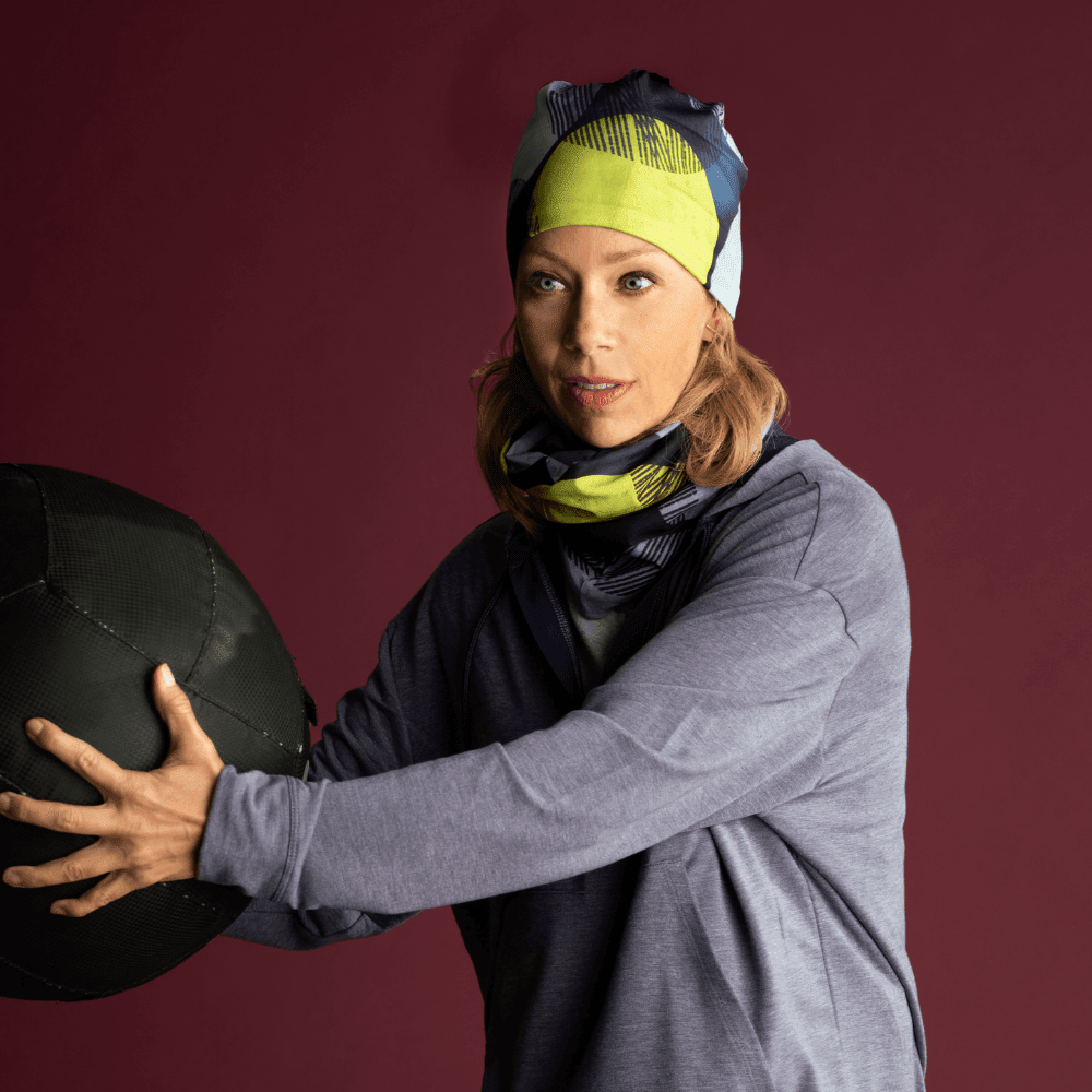 Femme portant une tuque et un cache-cou assortis à Motifs Jaunes tout en tenant un ballon d'exercice.