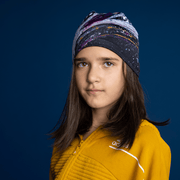 Proud young girl wearing the Lalita's Art Shop Abracadabra beanie model, with an abstract pattern on bamboo fabrics. Perfect hat for sports and outdoor activities, and suitable for the whole family