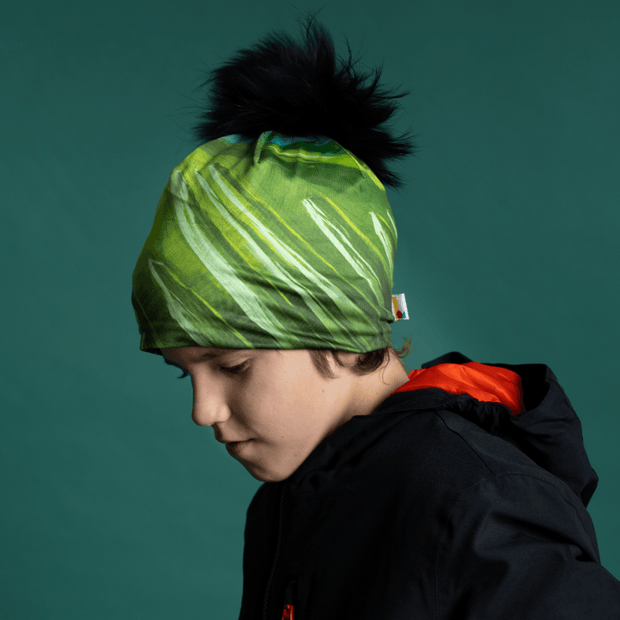 Boy side face wearing the Green Light beanie with black pompon by Andre Martel for the Lalita's Art Shop 22 collection.