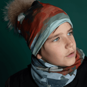 Young boy with sideways face wearing the Lachine beanie designed by Anhone. The 4 seasons streetart style beanie has a nice natural pompom. This bamboo hat adapts very well to outdoor activities.