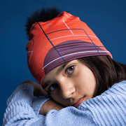 Young girl with her arms crossed and her head resting on her arms. She is wearing the Graphometrics Lalita's Art Shop toque illustrated by Valéry Goulet. This toque is perfect for running, yoga, tennis, basketball and cycling. This flamboyant hat is made of bamboo and wicks moisture away from your body during sports activities.