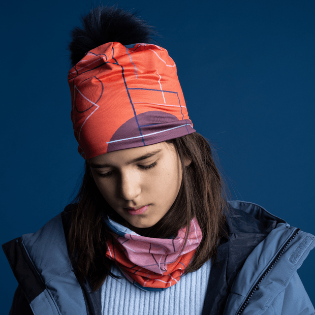Young girl looking down wearing the Pink Graphonetrics beannie, illustrated by Quebec artist Valéry Goulet. This cap will add a feminine touch to your sportswear.
