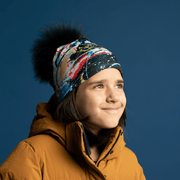 Girl wearing the Black bamboo toque with removable fur pompom. The beanie goes whell with Mustard, blue, gray, red and white jackets. 