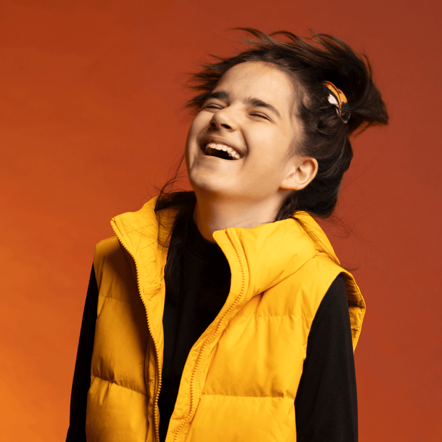Sportive girl laughing and wearing the Orange Owl Multifunctional tube as a scrunchie for the Lalita's Art Shop 24 collection