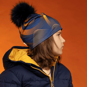 Young boy wearing his ski jacket and the Navy and Orange Sunrise Sport Beanie for Lalita's Art Shop