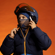 Young skier wearing his helmet with the Navy and Orange Sunrise Beanie and Multifunctional Tube by Zaire for Lalita's Art Shop