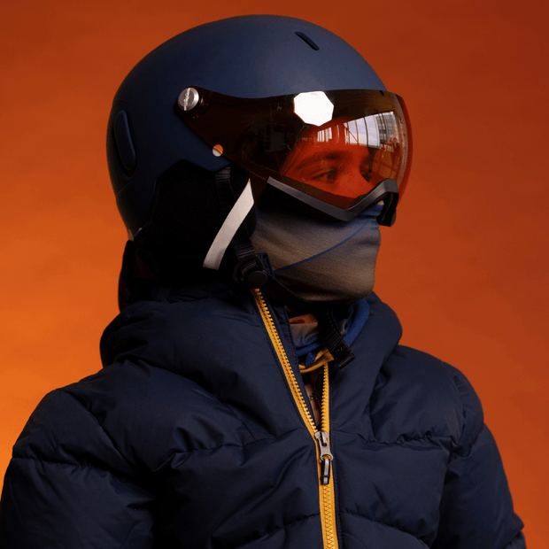 Kid wearing his ski helmet with the Navy and Orange Sunrise Multifunctional Bandana by Zaire for Lalita's Art Shop