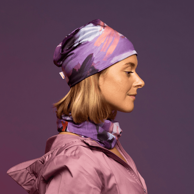 Woman wearing the Pink and Lilac Tulips Multifunctional Tube and assorted beanie by Catherine Parent for Lalita's Art Shop