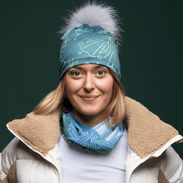 Young woman wearing the Blue Green multifunctional tube with assorted pompom beanie by Valery Goulet for Lalita's Art Shop
