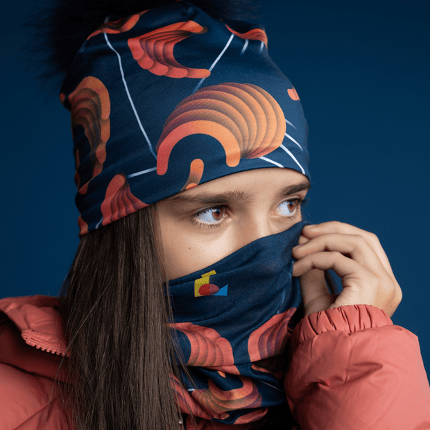  Young girl, wearing the Sound Barrier designed by Zaire.  She covers the lower part of her face with the multifunction tube that matches the toque. Lalita's Art Shop's four season hat  are designed for outdoor sports and camping. Perfect gift for the whole family!