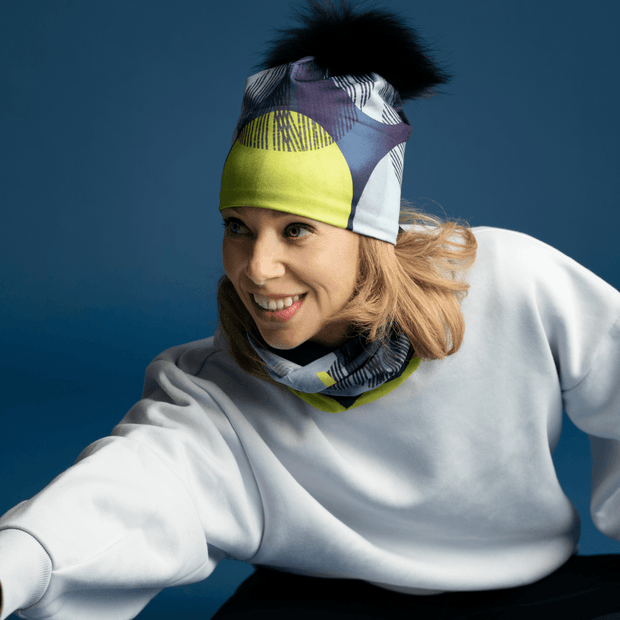 Woman stretching with Yellow Dots duo beanie / tube. 